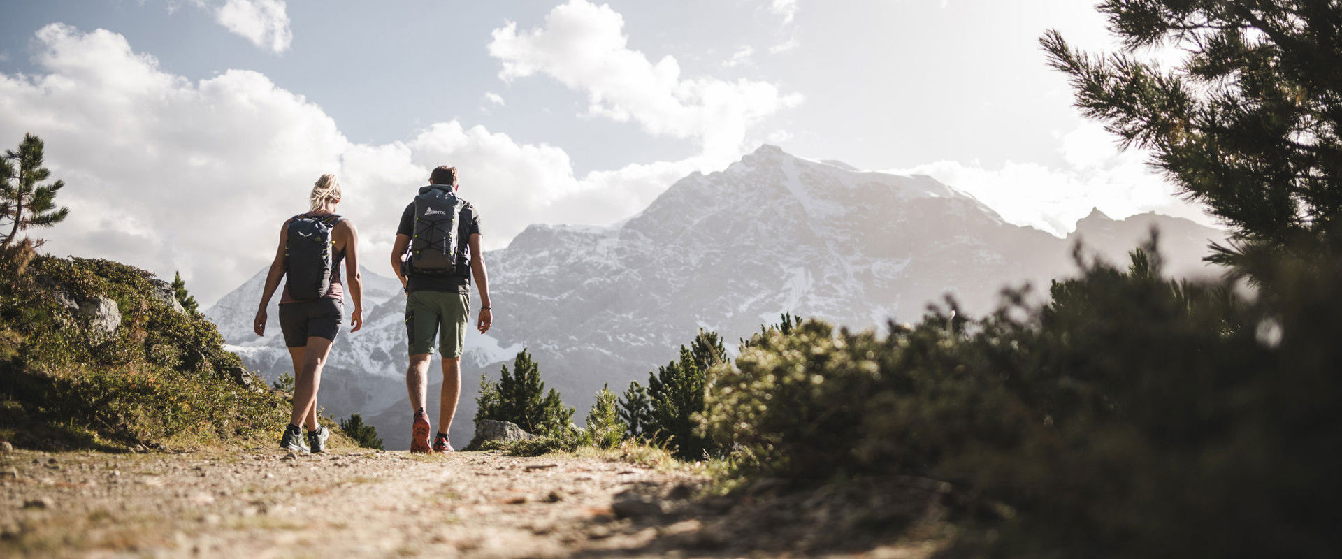 Hiking in summer in South Tyrol Couple strolls along a quiet path with beautiful mountain views.