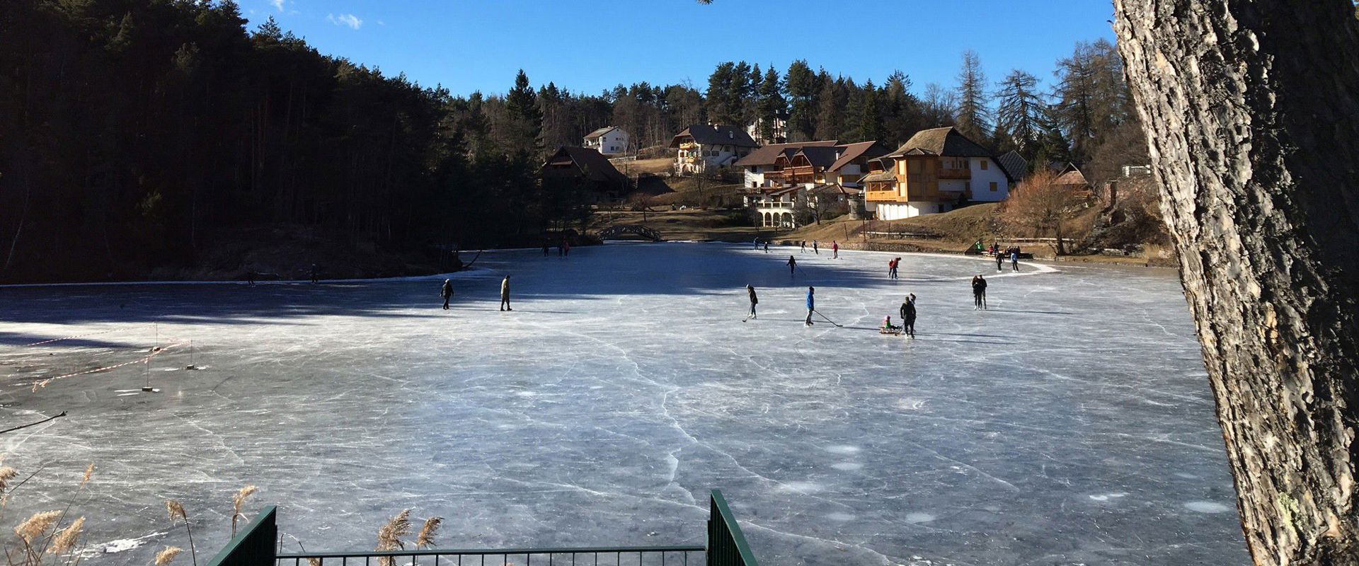 Lake Wolfsgruben on Ritten Frozen lake with ice skaters.