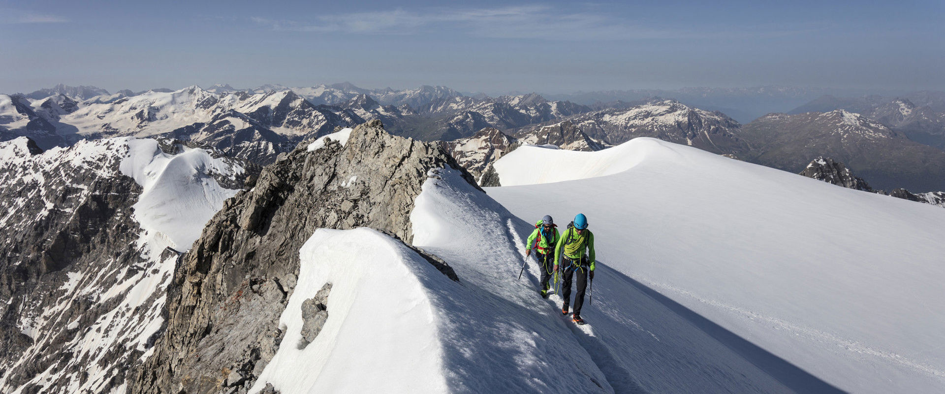 Ski touring in South Tyrol Two athletes reach the mountain summit on touring skis.